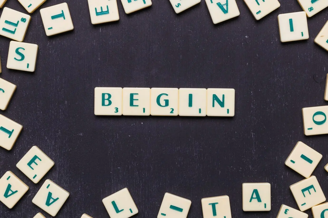 Das Wort „Begin“ aus Scrabble-Buchstaben gelegt.